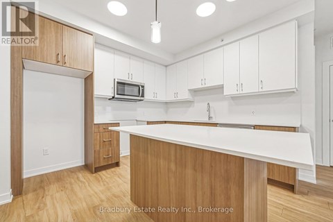 A kitchen with white cabinets and a wooden island.