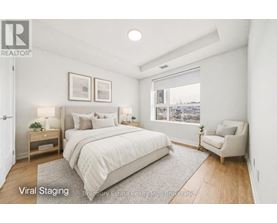 A bedroom with a large bed and a chair.