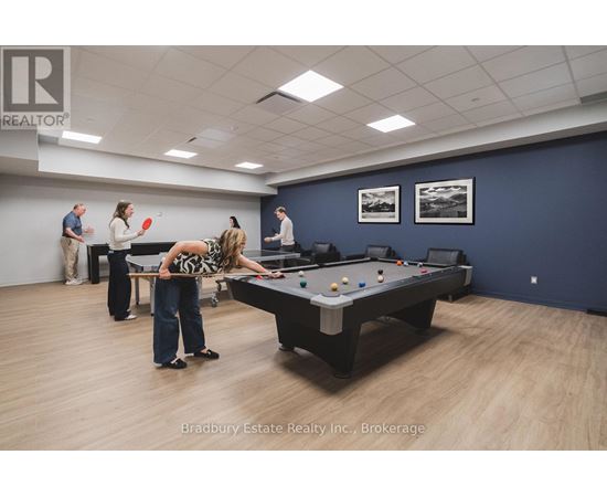 A woman is playing pool in a room with a pool table and a few other people.