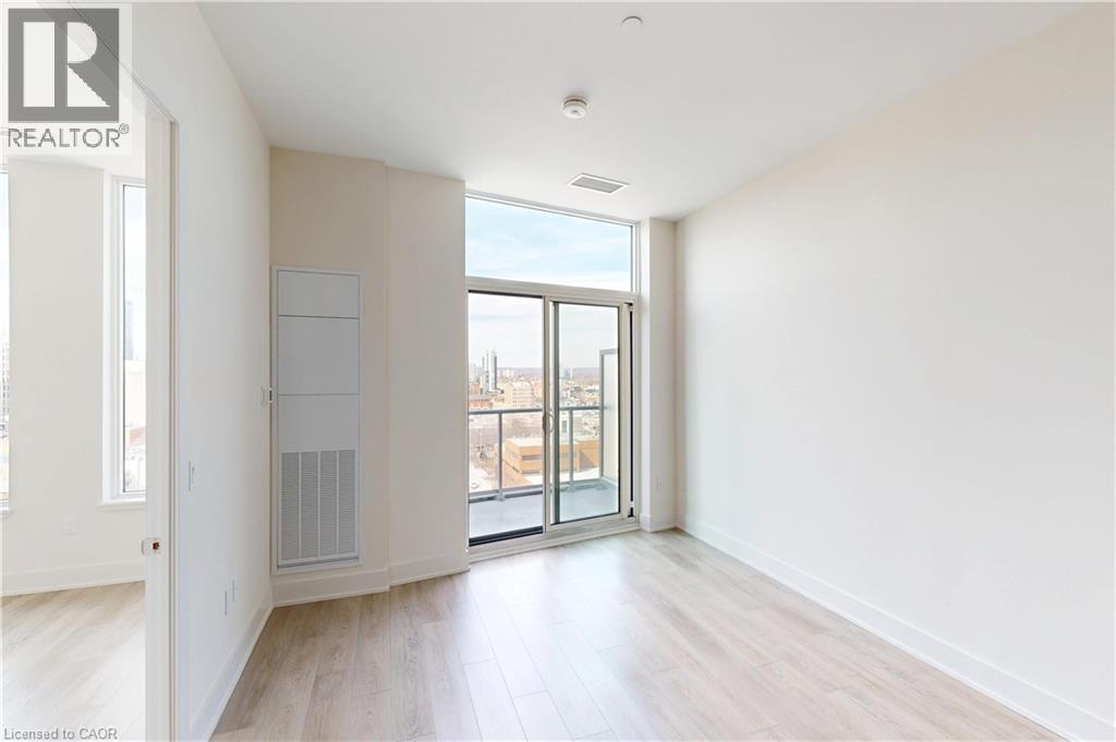 A spacious room with a sliding glass door leading to a balcony.