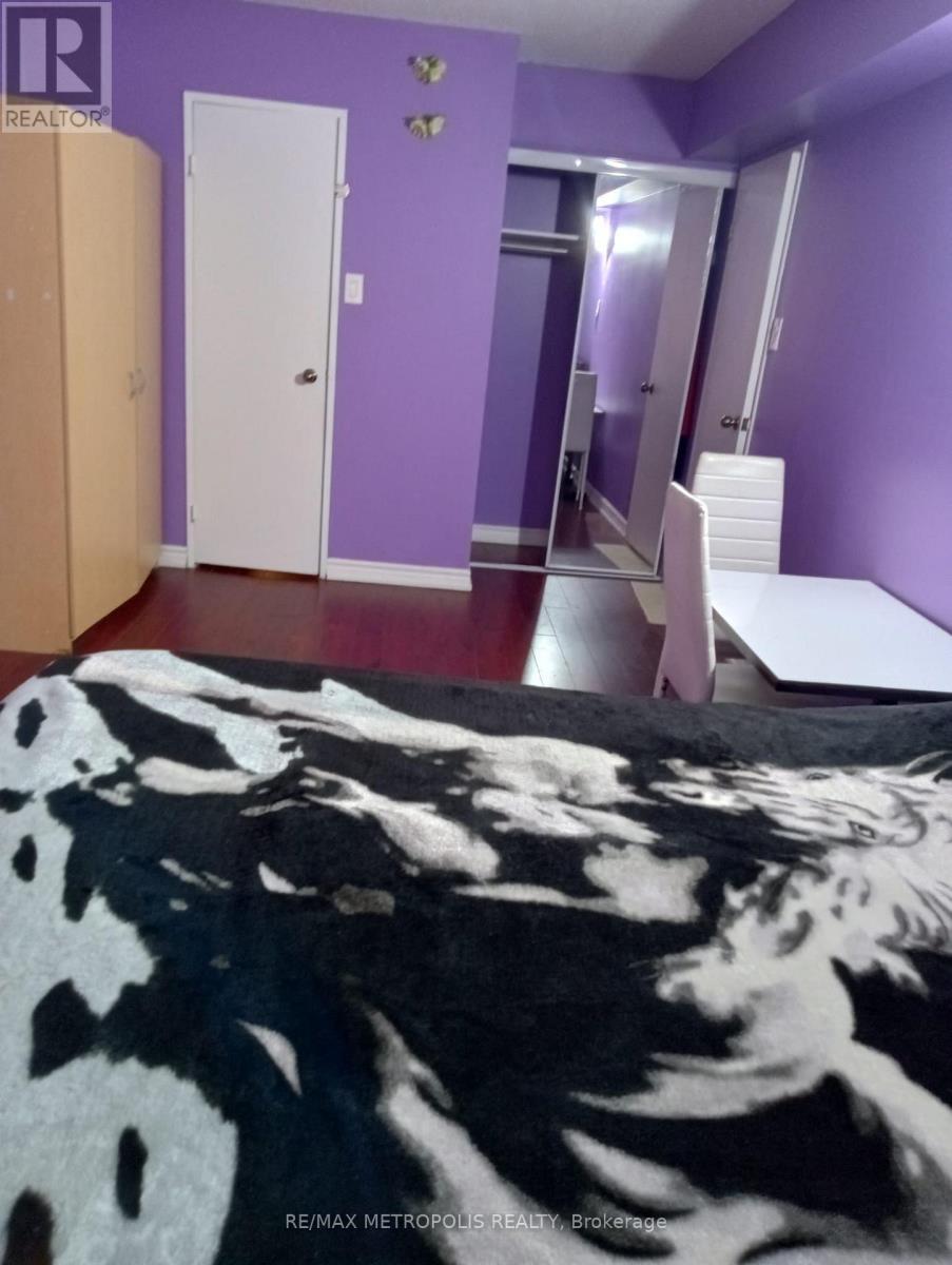 A bedroom with purple walls and a cowhide rug.