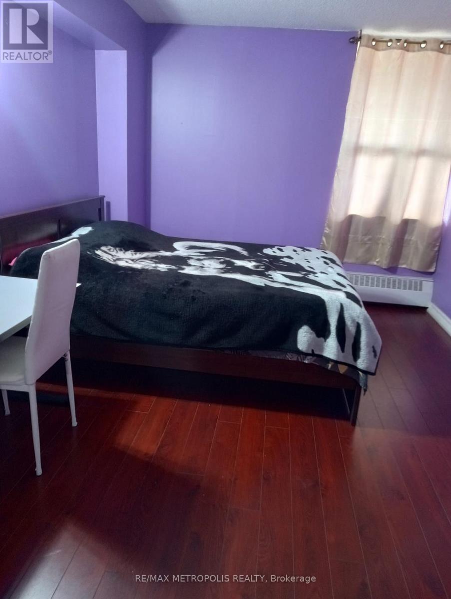 A bedroom with a bed, chair, and purple walls.