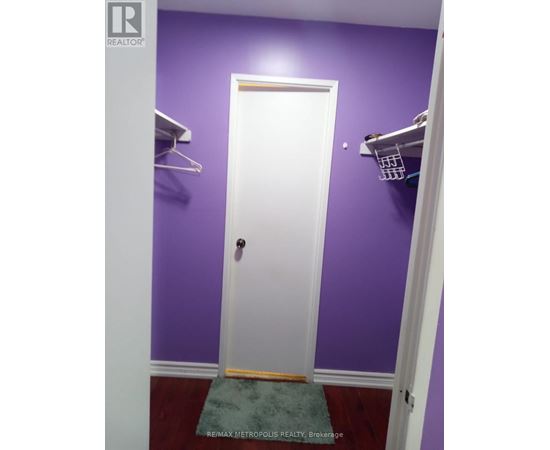 A white door is in a room with purple walls.