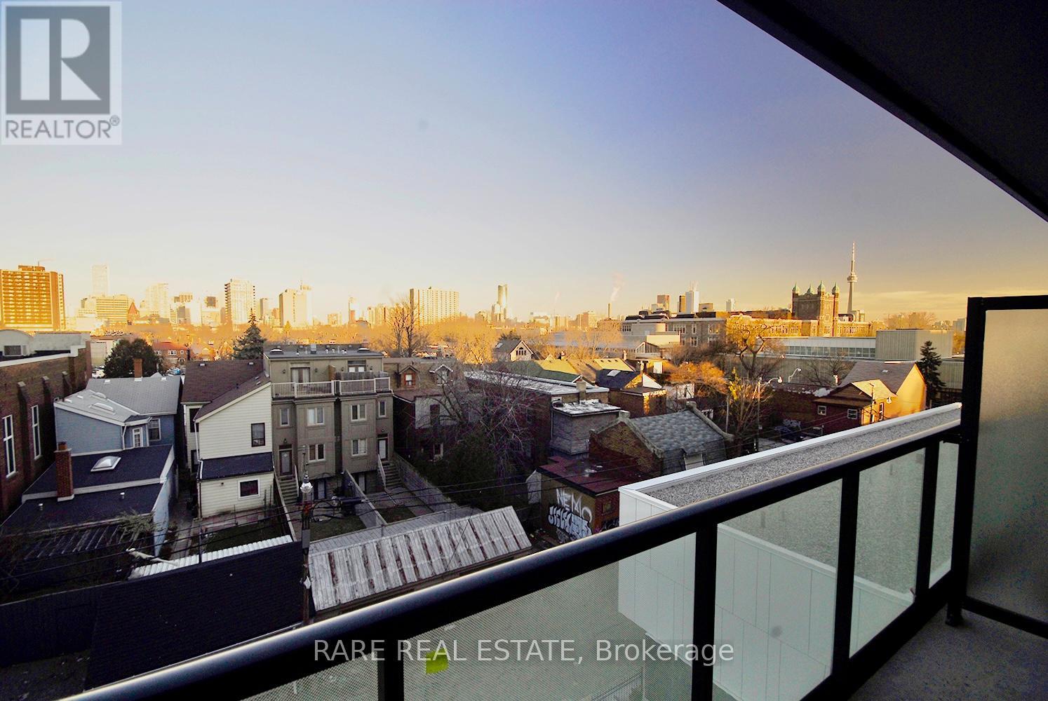 A balcony overlooks a cityscape with buildings and trees.