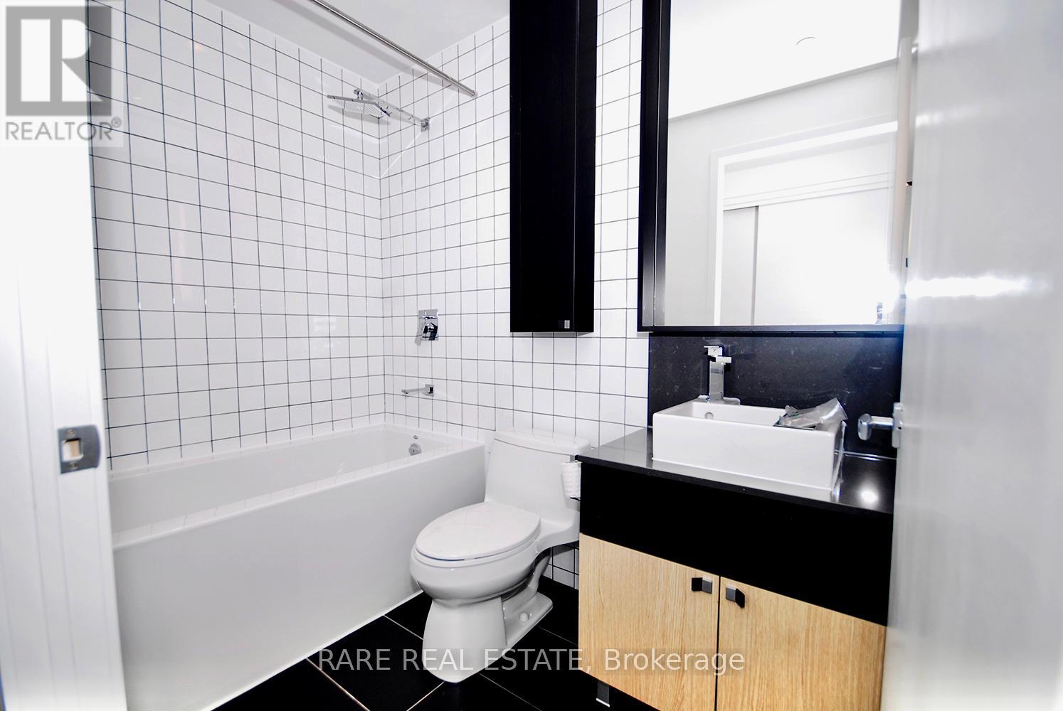 A white toilet is in a black and white bathroom.