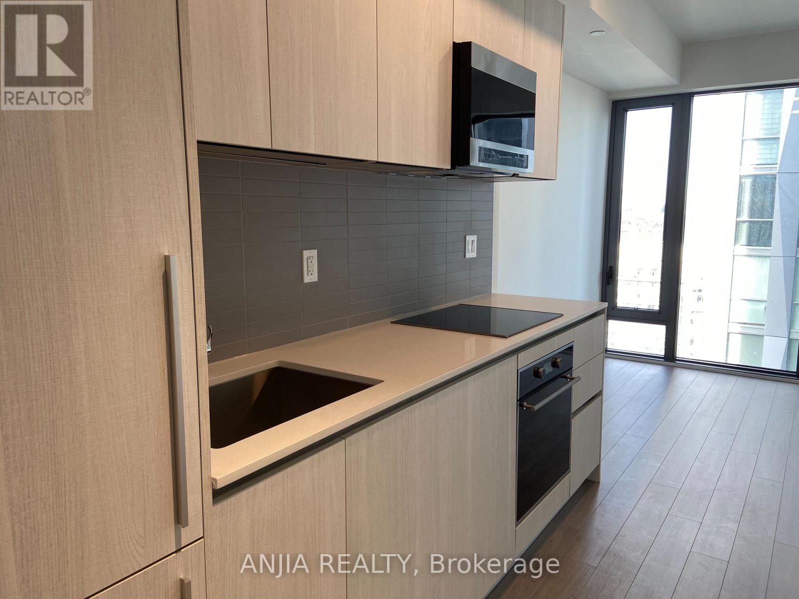 A modern kitchen with wooden cabinets and a black countertop.