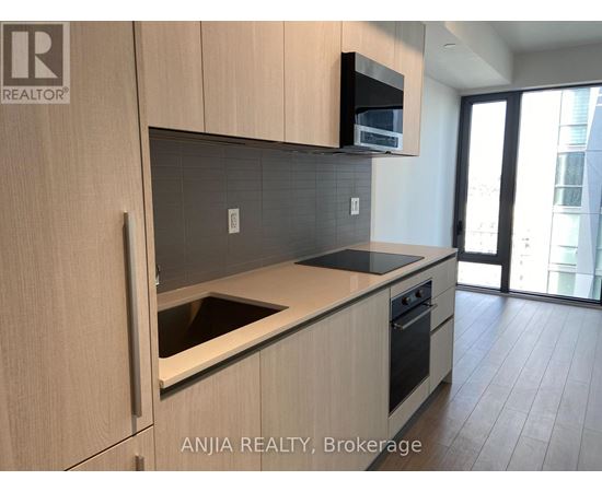 A modern kitchen with wooden cabinets and a black countertop.