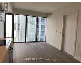 A spacious room with a view of a cityscape through large windows.