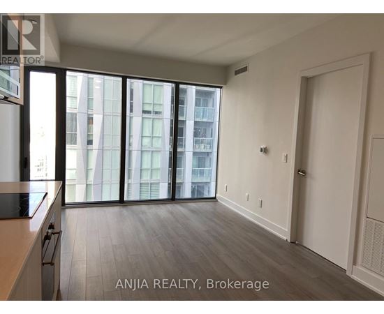 A spacious room with a view of a cityscape through large windows.