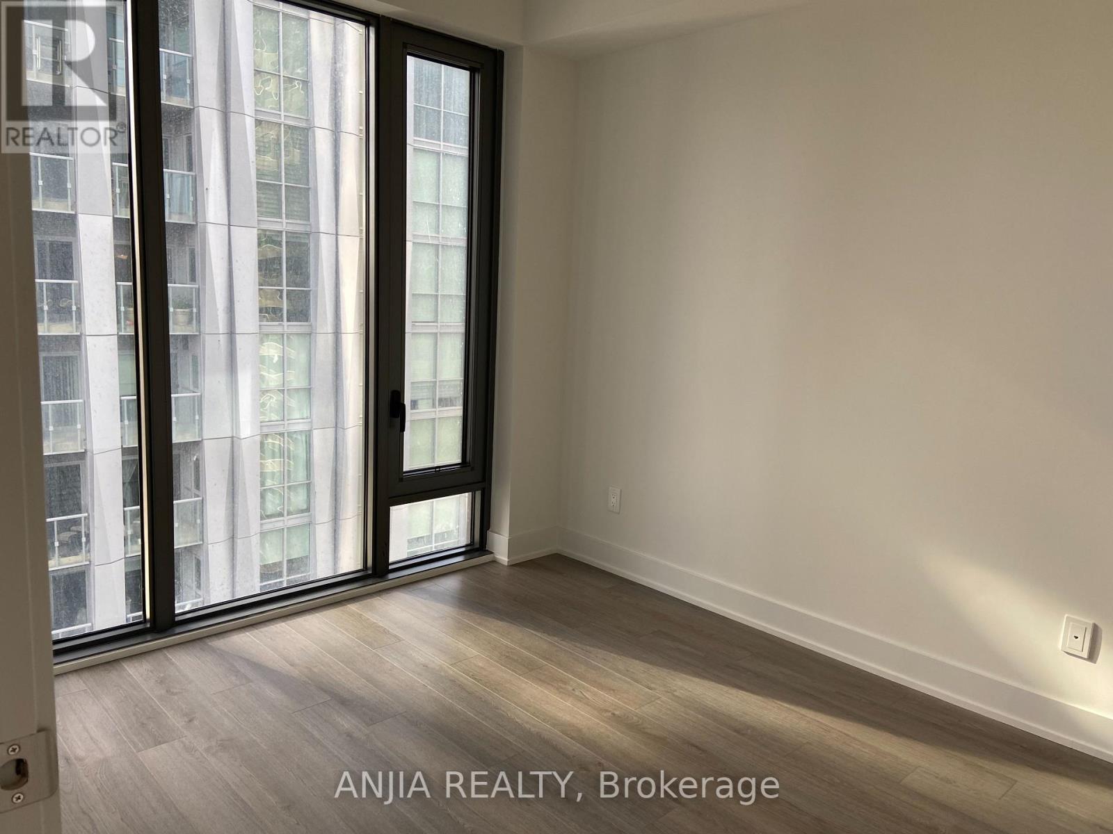 A room with a sliding door and a window showing a city view.