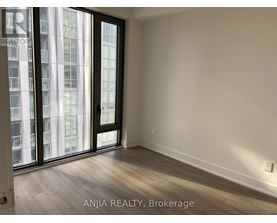 A room with a sliding door and a window showing a city view.