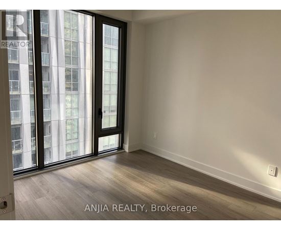 A room with a sliding door and a window showing a city view.