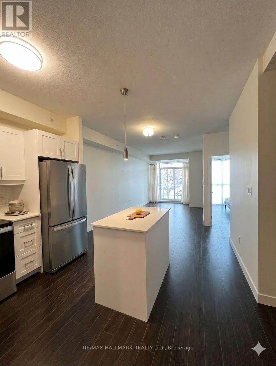 A kitchen with white cabinets and a stainless steel refrigerator.