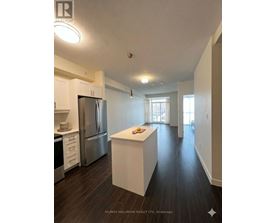 A kitchen with white cabinets and a stainless steel refrigerator.