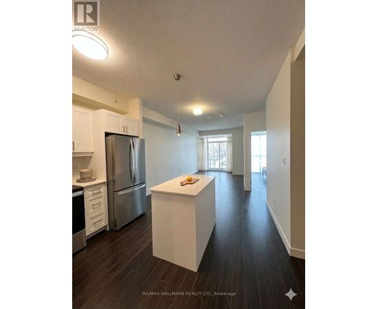 A kitchen with white cabinets and a stainless steel refrigerator.