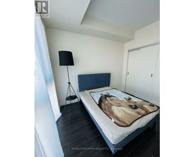 A bedroom with a bed covered in a horse print sheet.
