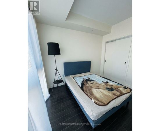A bedroom with a bed covered in a horse print sheet.