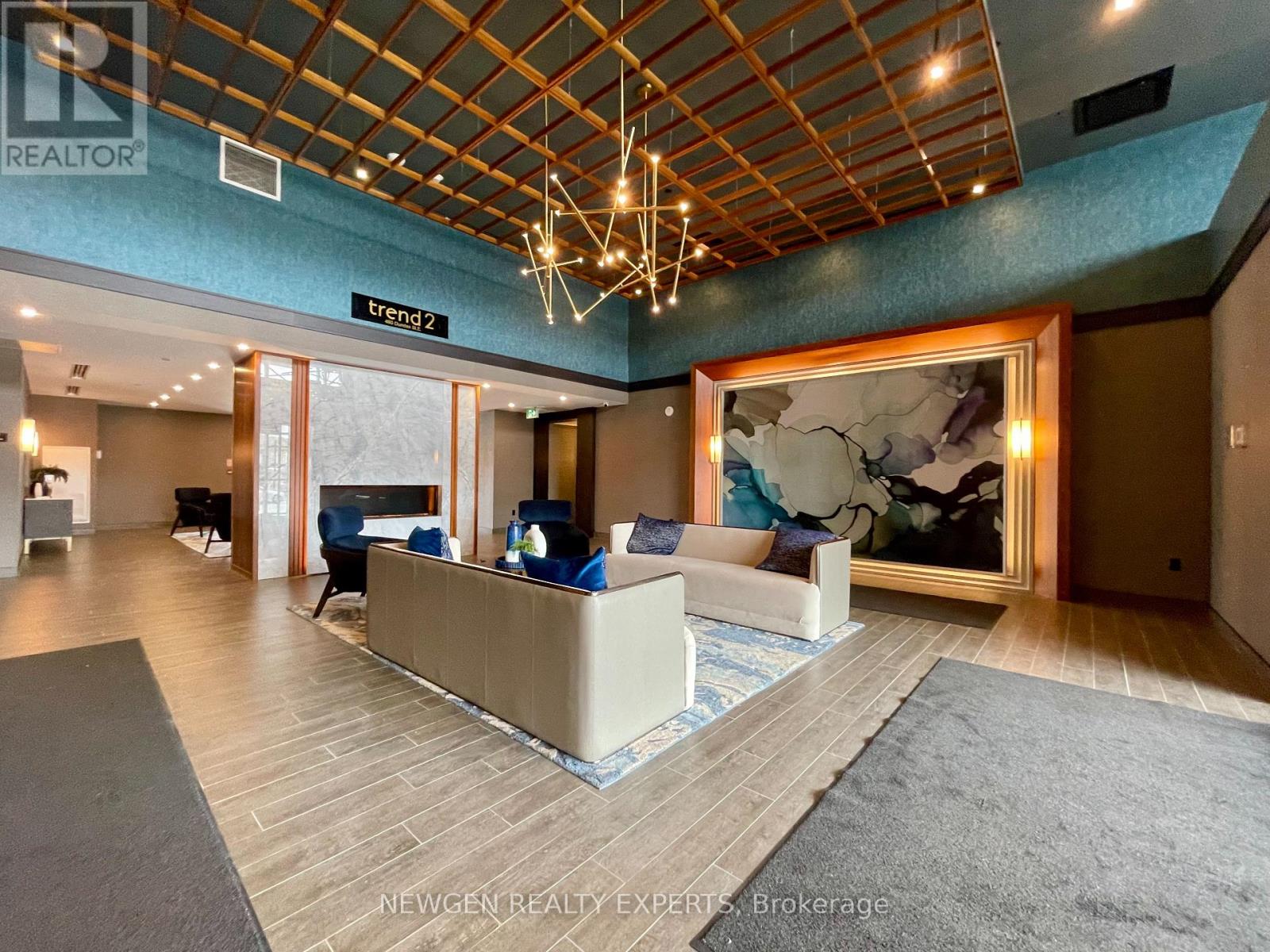A spacious office lobby with a reception desk and a large painting on the wall.