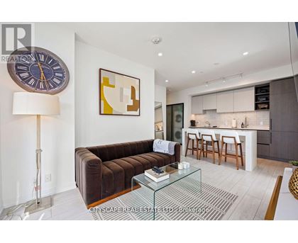 A living room with a brown couch and a glass coffee table.