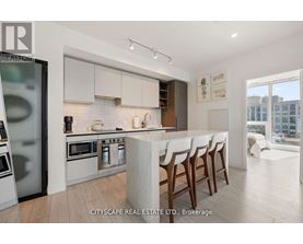 A modern kitchen with white cabinets and a marble island.