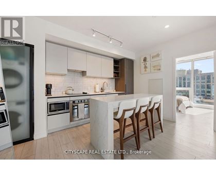 A modern kitchen with white cabinets and a marble island.