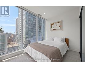 A bedroom with a large bed and a view of the city.