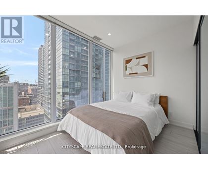 A bedroom with a large bed and a view of the city.