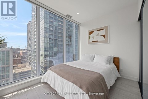 A bedroom with a large bed and a view of the city.