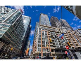 A cityscape with tall buildings and a clear blue sky.