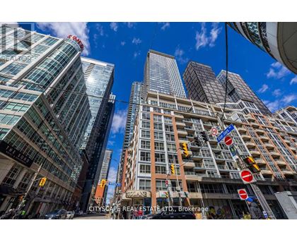 A cityscape with tall buildings and a clear blue sky.