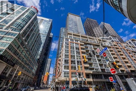 A cityscape with tall buildings and a clear blue sky.
