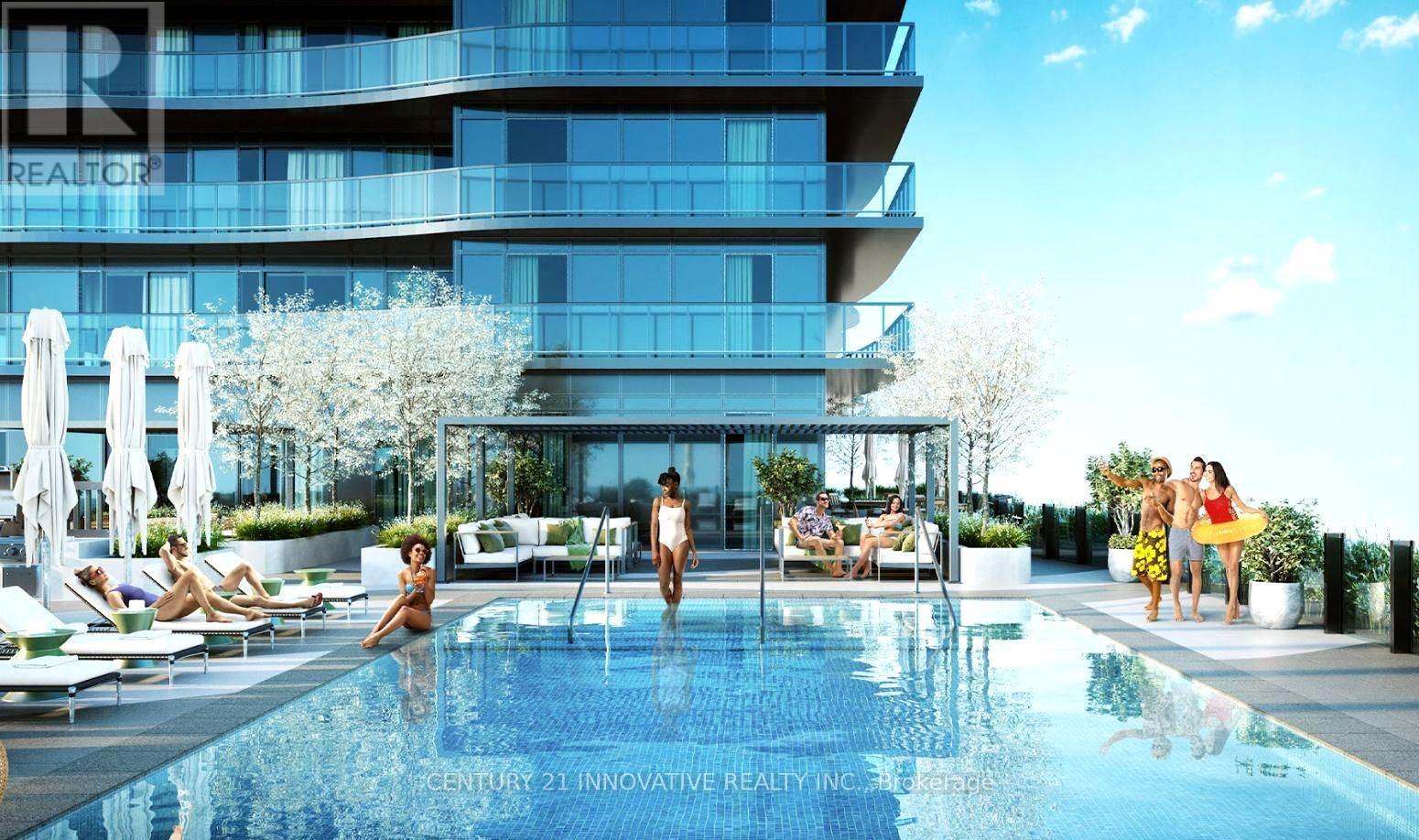 A modern building with a pool and people relaxing by it.