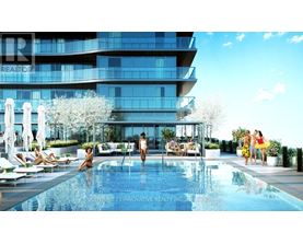 A modern building with a pool and people relaxing by it.