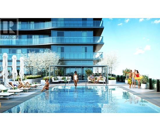 A modern building with a pool and people relaxing by it.
