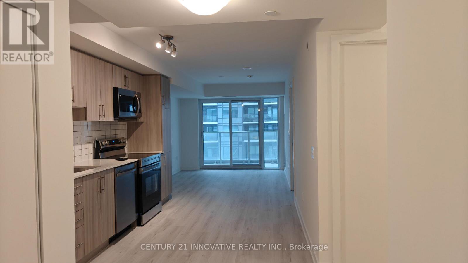 A kitchen with wooden cabinets and black appliances is shown.