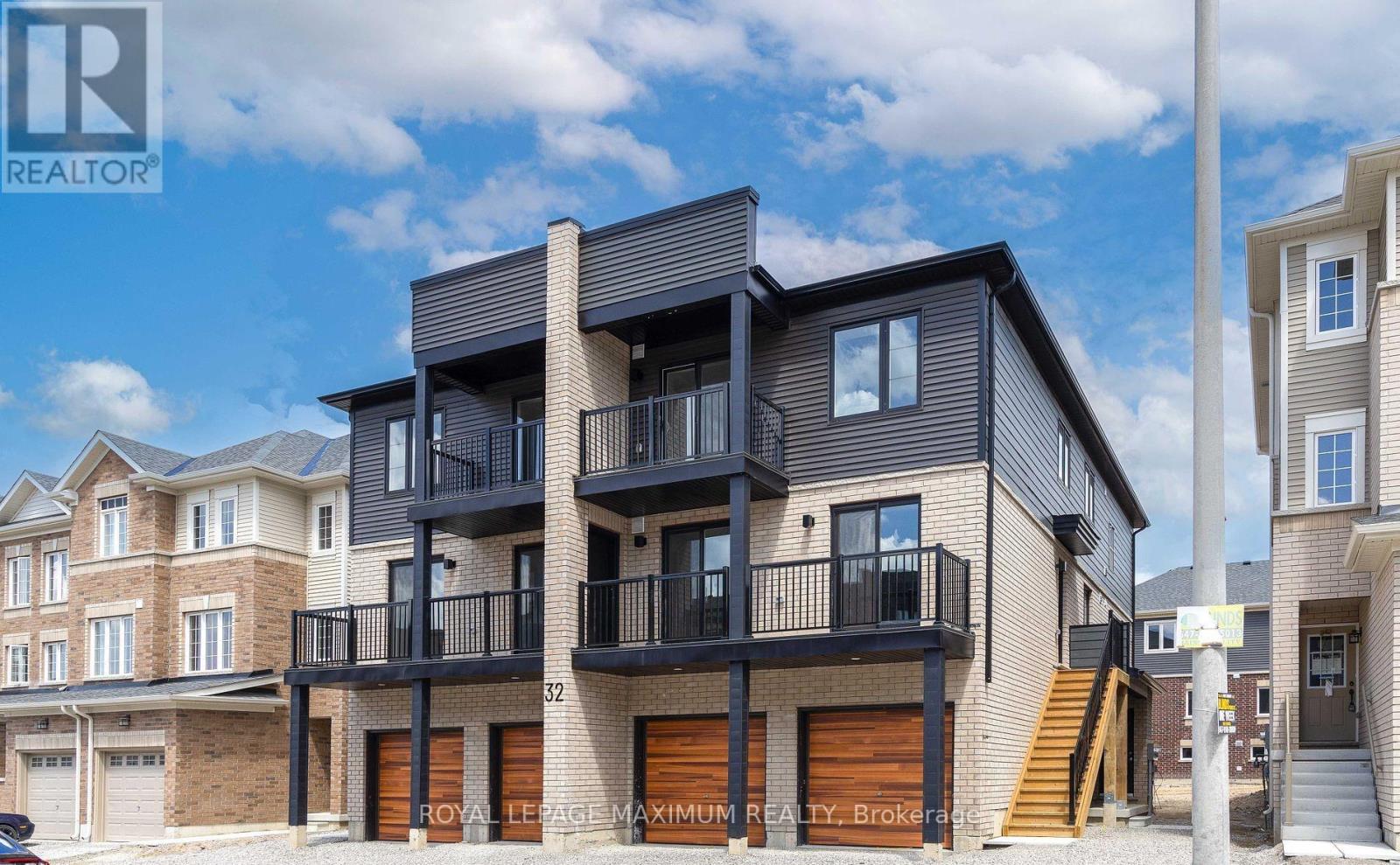 A modern multi-story residential building with balconies and garage doors.