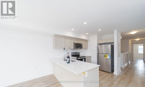 A kitchen with white cabinets and a stainless steel refrigerator.