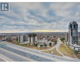 A cityscape with a highway and buildings under a cloudy sky.