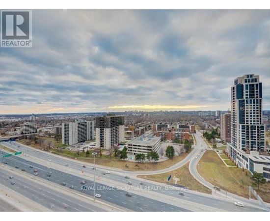 A cityscape with a highway and buildings under a cloudy sky.