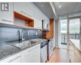 A modern kitchen with white cabinets and a stainless steel sink.