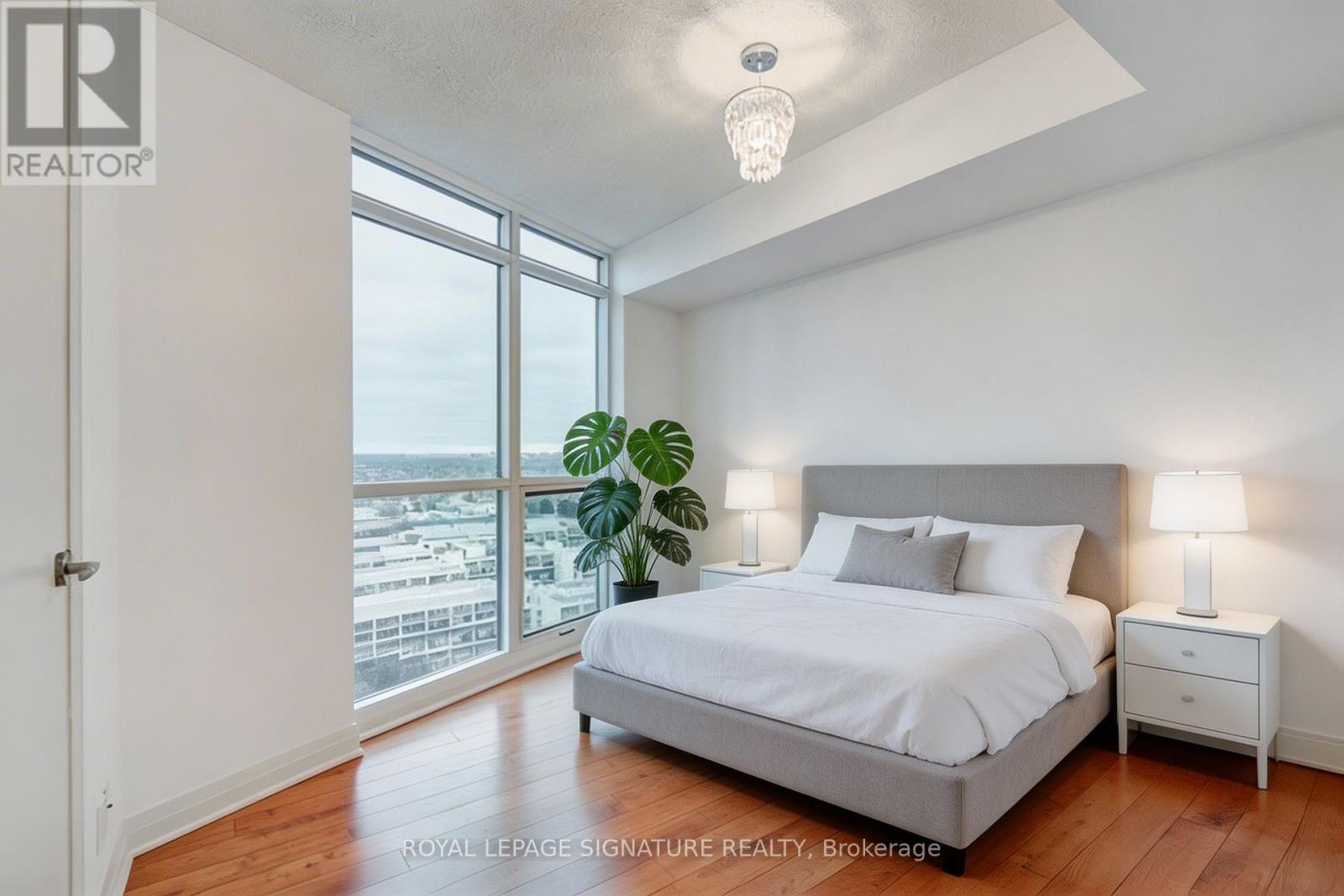 A bedroom with a large bed and a view of the city.