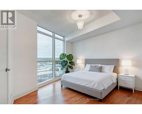A bedroom with a large bed and a view of the city.