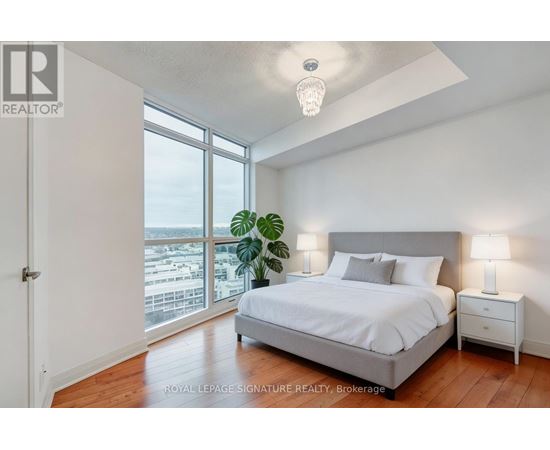 A bedroom with a large bed and a view of the city.