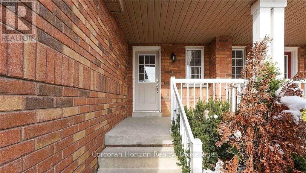 A brick house with a white door and a porch.