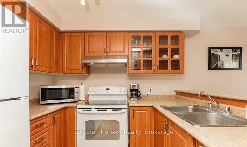 A kitchen with wooden cabinets and a white fridge.