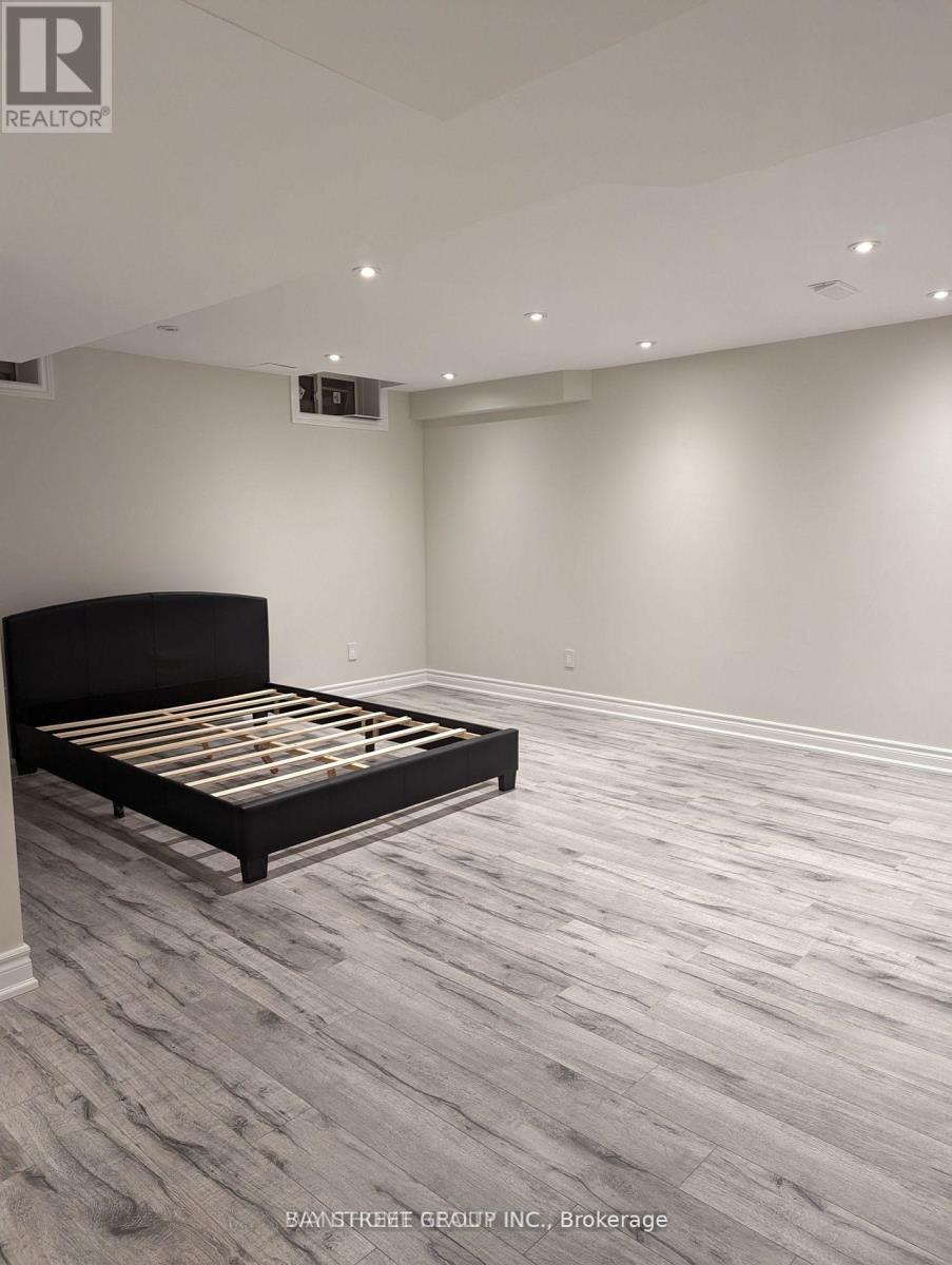 A bedroom with a bed and wooden flooring.