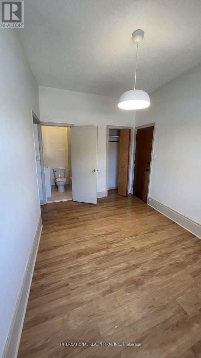 A long hallway with wood floors and white walls.