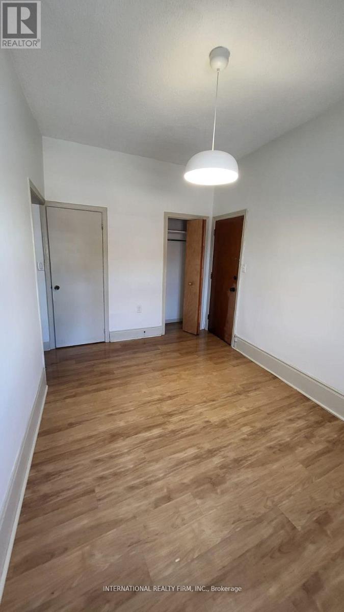 A room with wooden floors and two doors.