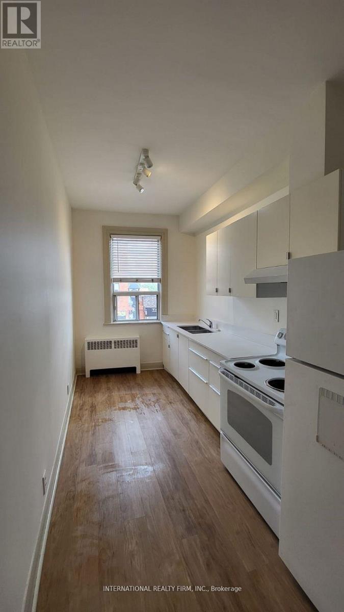 A kitchen with white appliances and wooden floors.