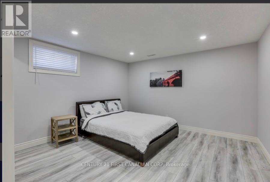 A bedroom with a large bed and a wooden nightstand.